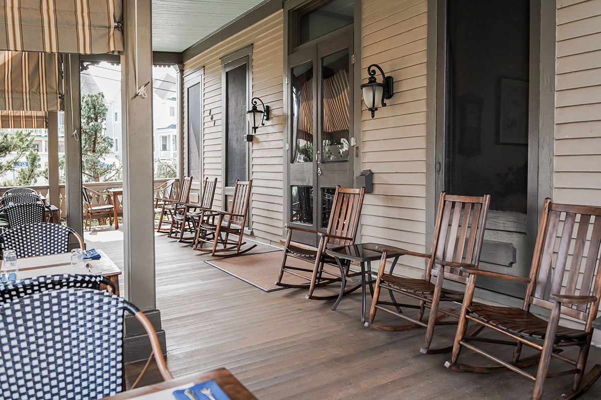 Rocking chairs and dining tables on the porch of the Mooring
